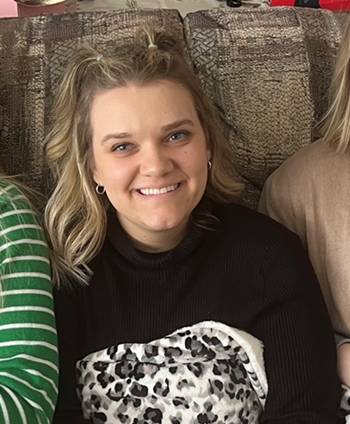 Allie Goeddeke sitting on a couch and smiling